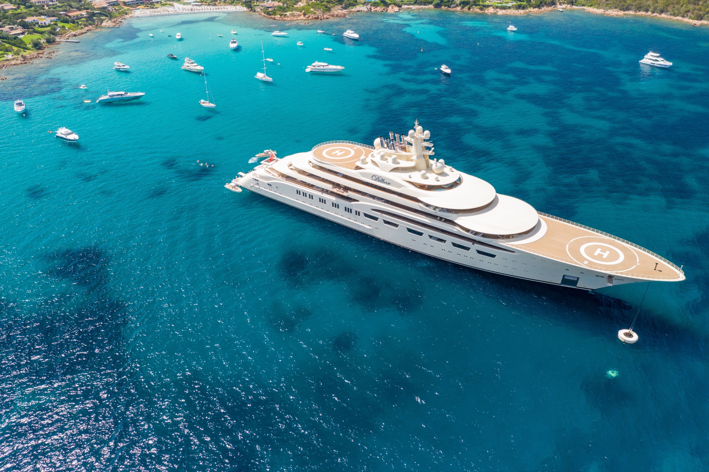 Aerial view of a superyacht anchored in the turquoise bay of Porto Cervo