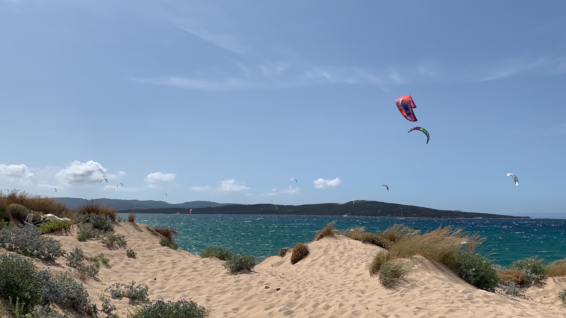 Kitesurfers in flight above Porto Pollo's dunes